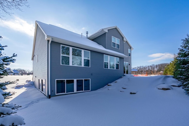 view of snow covered rear of property