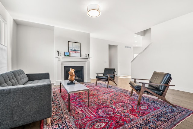 living room with wood-type flooring and a brick fireplace