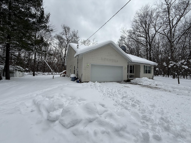 snow covered property featuring a garage