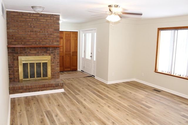 unfurnished living room with ceiling fan, light hardwood / wood-style floors, and a brick fireplace