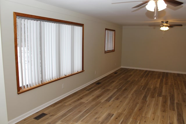 spare room with dark wood-type flooring and ceiling fan