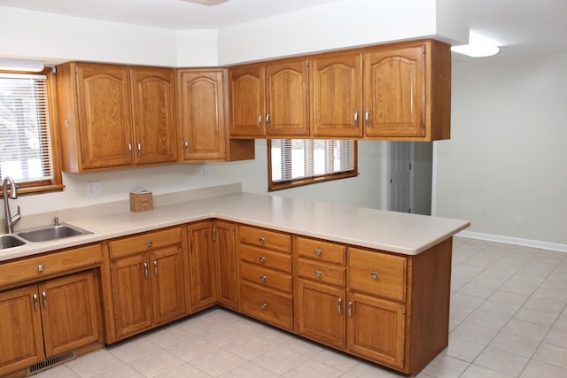 kitchen with sink, light tile patterned floors, and kitchen peninsula