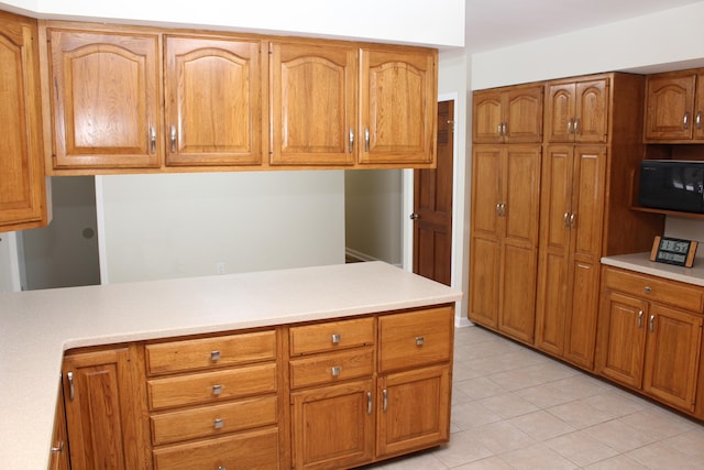 kitchen featuring light tile patterned floors and kitchen peninsula