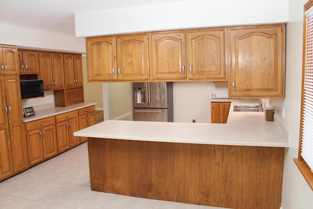 kitchen with sink, kitchen peninsula, and stainless steel refrigerator with ice dispenser