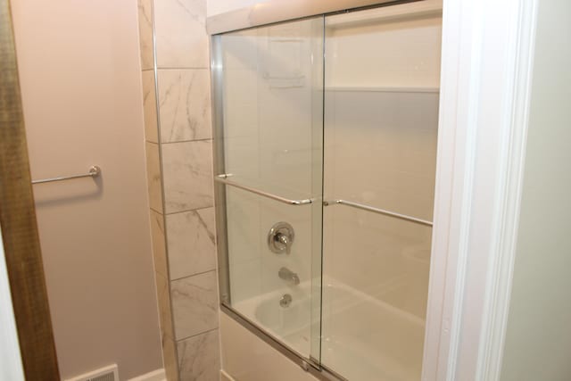 bathroom featuring combined bath / shower with glass door