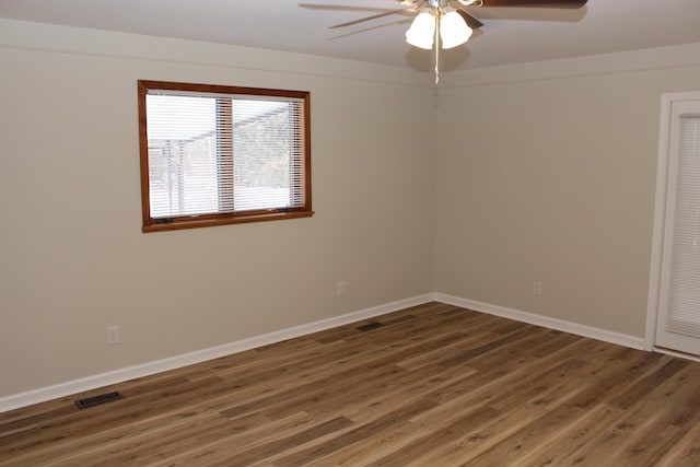 empty room featuring dark wood-type flooring and ceiling fan