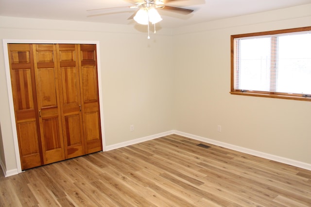 unfurnished bedroom with ceiling fan, light hardwood / wood-style floors, and a closet