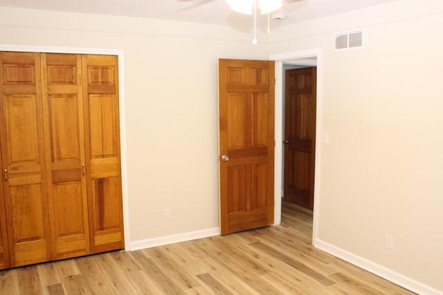 unfurnished bedroom with light hardwood / wood-style floors, a closet, and ceiling fan