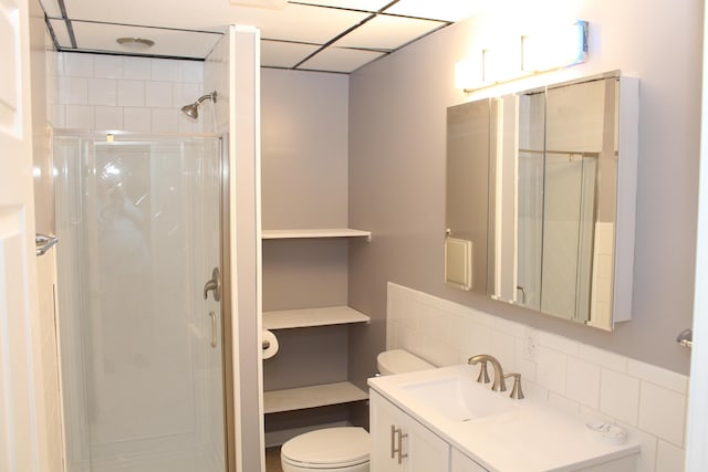 bathroom featuring vanity, a shower with shower door, and toilet