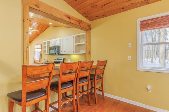 dining area featuring wood ceiling, vaulted ceiling, and wood-type flooring