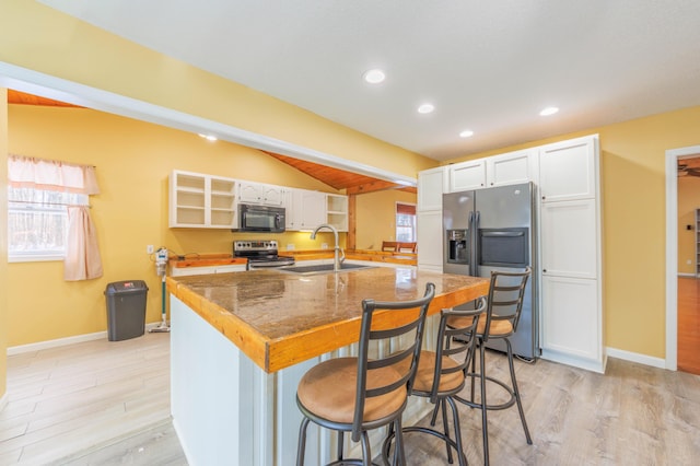 kitchen with white cabinetry, sink, a breakfast bar, and appliances with stainless steel finishes