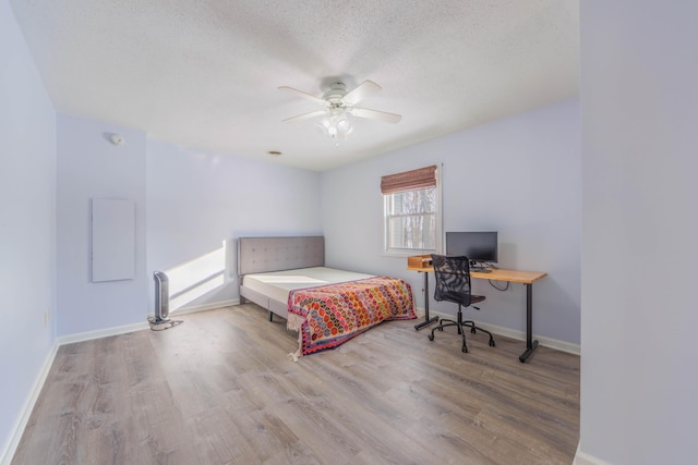 bedroom featuring a textured ceiling, light hardwood / wood-style flooring, and ceiling fan