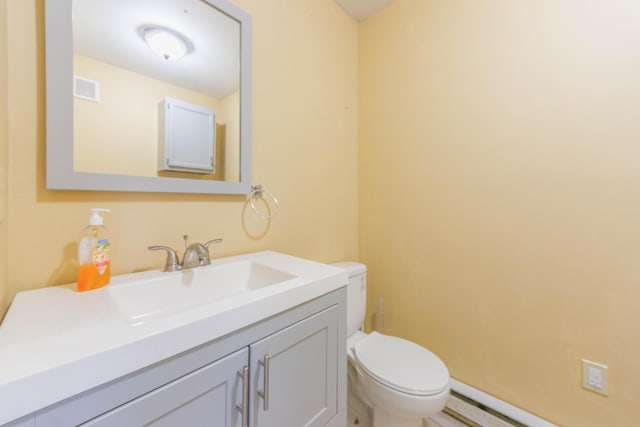 bathroom with vanity, baseboard heating, and toilet