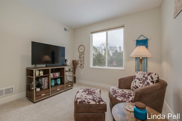 carpeted living area with visible vents and baseboards