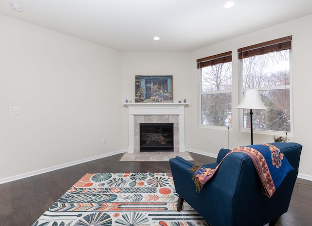 living room with dark hardwood / wood-style flooring and a tile fireplace