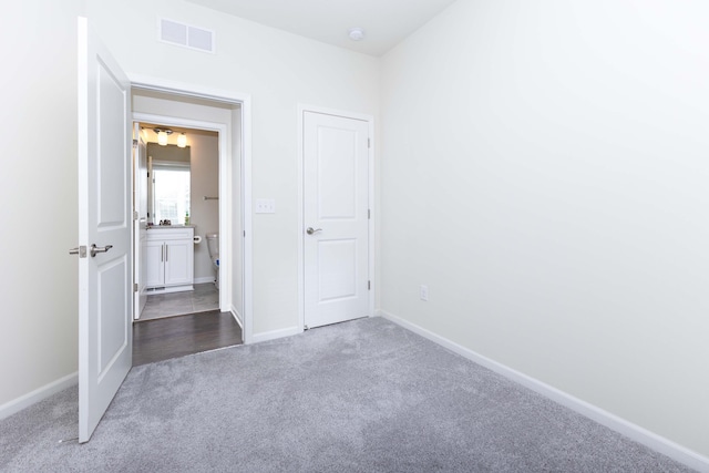 unfurnished bedroom with dark colored carpet