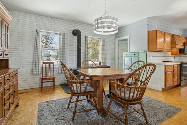 dining room featuring washer / dryer, a wealth of natural light, light parquet floors, and brick wall