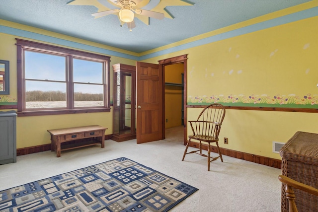 living area with light colored carpet and ceiling fan