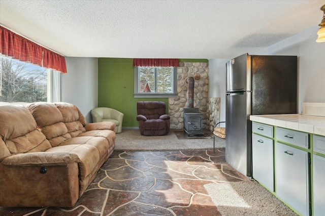 living room with plenty of natural light, a textured ceiling, and a wood stove