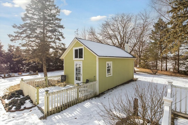 snow covered property featuring an outdoor structure