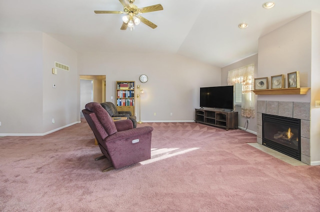 living room featuring ceiling fan, lofted ceiling, carpet, and a tile fireplace