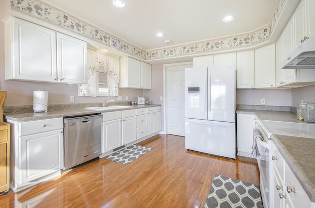 kitchen with sink, white appliances, light hardwood / wood-style flooring, ornamental molding, and white cabinets