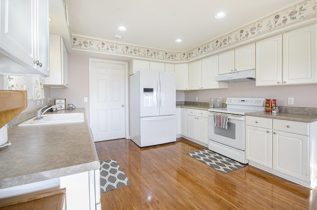 kitchen featuring white cabinetry, sink, white appliances, and dark hardwood / wood-style floors