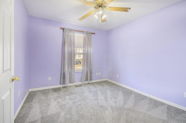 carpeted spare room featuring ceiling fan