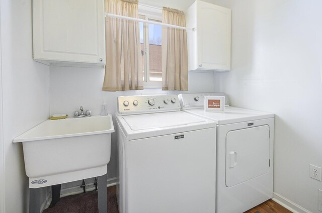 laundry room featuring cabinets, washer and clothes dryer, and sink