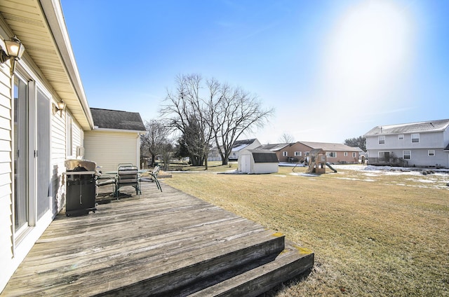 wooden terrace with a shed, a grill, and a yard