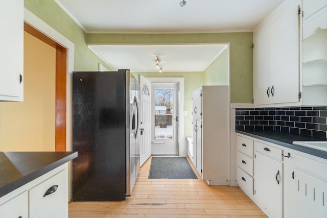 kitchen featuring crown molding, stainless steel fridge with ice dispenser, light wood-type flooring, white cabinets, and backsplash