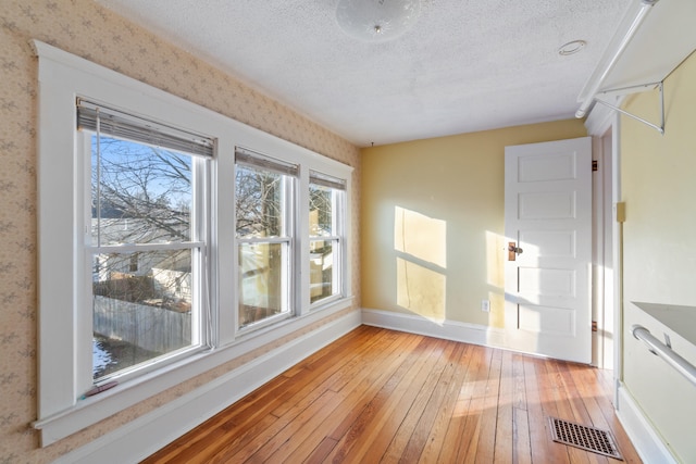 interior space with a textured ceiling and light wood-type flooring