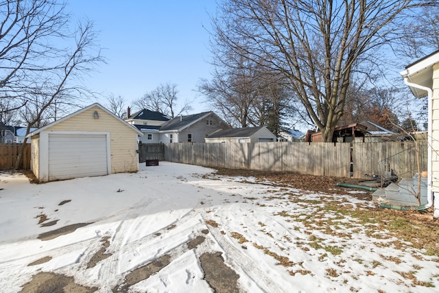 yard layered in snow with a garage and an outdoor structure