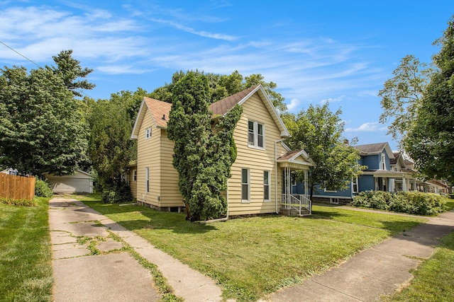 view of front facade with a garage, an outdoor structure, and a front lawn