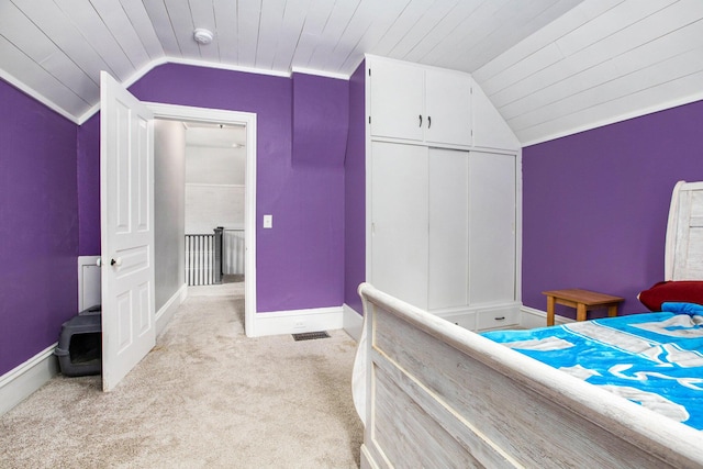 carpeted bedroom featuring vaulted ceiling, wooden ceiling, crown molding, and a closet