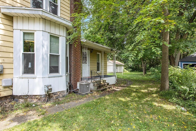 view of side of home with a lawn and central air condition unit