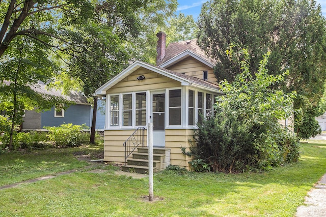 view of front of property with a sunroom and a front lawn