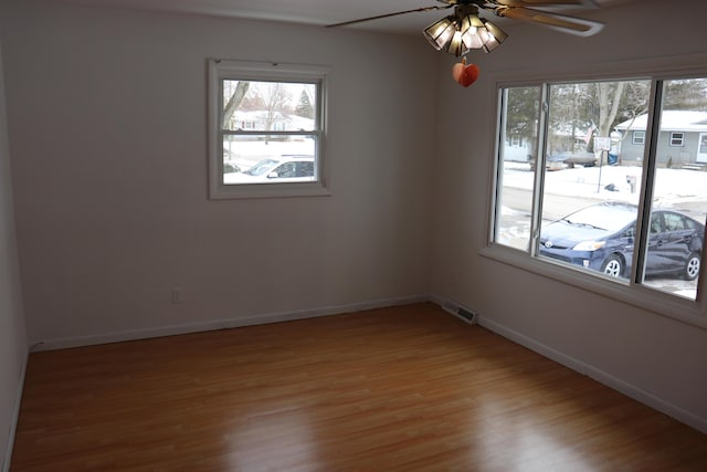 spare room featuring hardwood / wood-style floors, a wealth of natural light, and ceiling fan