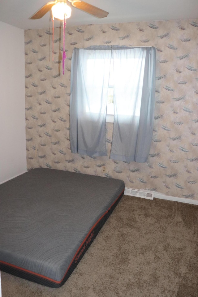 unfurnished bedroom featuring ceiling fan and carpet