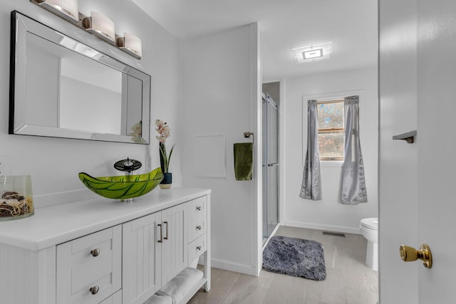 bathroom featuring vanity, toilet, and walk in shower