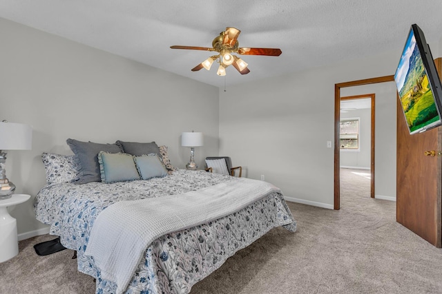 carpeted bedroom featuring a textured ceiling and ceiling fan