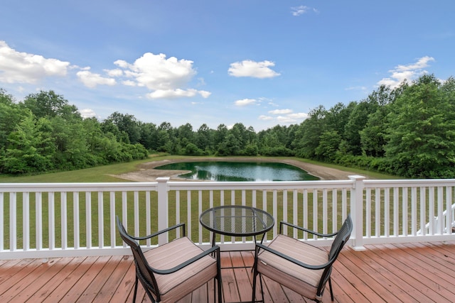 wooden terrace featuring a water view and a yard