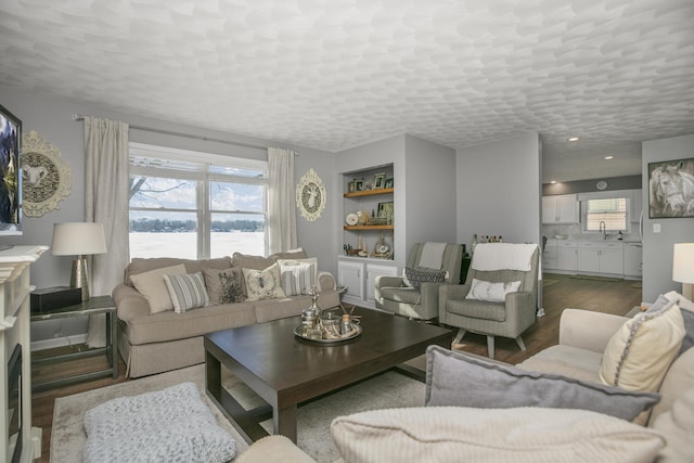 living room featuring a water view, a textured ceiling, and light wood-type flooring