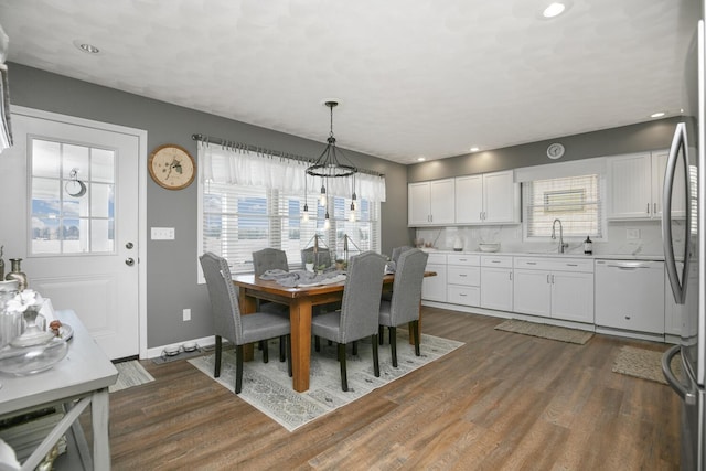 dining room featuring dark wood-type flooring, a healthy amount of sunlight, and sink