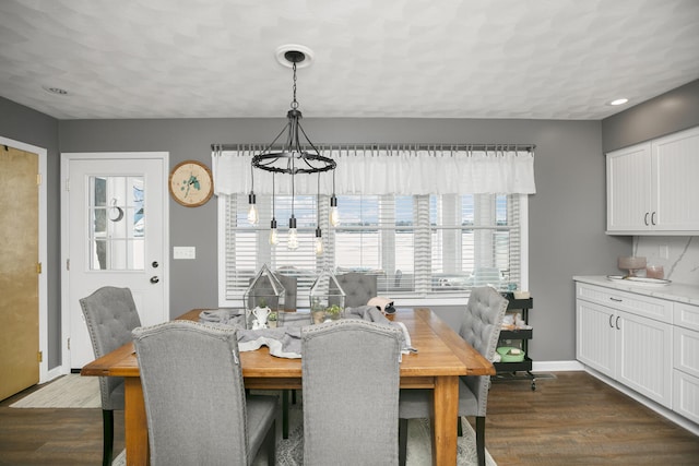 dining space featuring dark hardwood / wood-style flooring and a chandelier