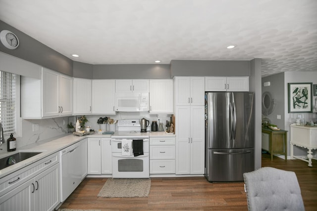 kitchen featuring white cabinetry, sink, white appliances, and dark hardwood / wood-style flooring