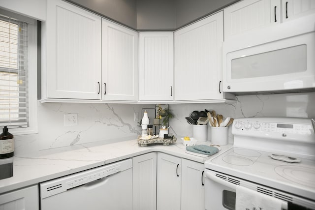 kitchen featuring white appliances, decorative backsplash, and white cabinets