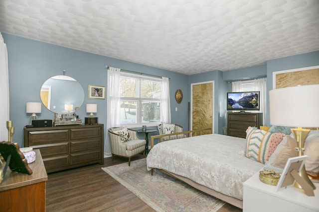 bedroom with dark hardwood / wood-style floors and a textured ceiling