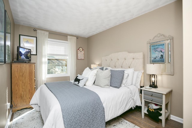 bedroom with dark hardwood / wood-style floors