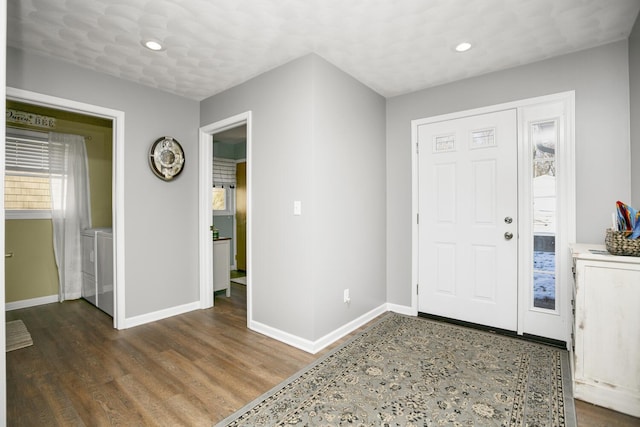 entrance foyer with dark hardwood / wood-style floors and washing machine and clothes dryer